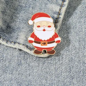 Makroaufnahme einer klassischen Weihnachtsmann-Emaille-Anstecknadel an einer Jeansjacke