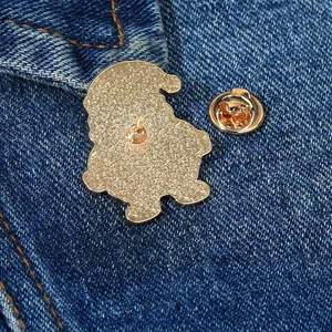 Goldene Weihnachts-Emaille-Anstecknadel mit Schmetterlingsverschluss auf Denim