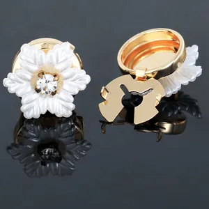Macro shot of camellia cufflinks with pearl petals, gold base and central crystal