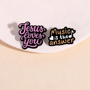 Set of two colorful enamel brooches with Jesus loves you and Music is the answer quotes