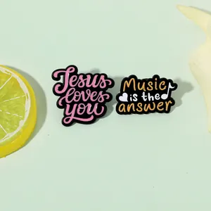 Enamel pins featuring Jesus Loves You and Music Is The Answer slogans in colorful metal alloy