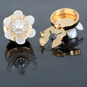 Detailed view of camellia cufflink featuring white petals and a center pearl detail