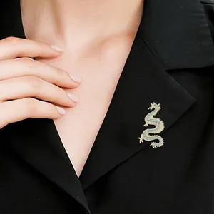Gothic gold-tone dragon brooch with blue rhinestones pinned on a black suit lapel