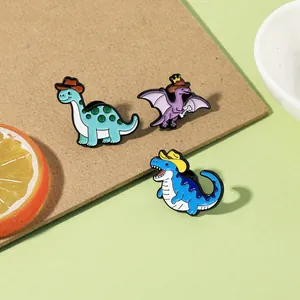 Dettaglio ravvicinato di un set di spille in smalto con dinosauri su carta kraft marrone