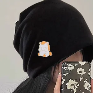 Nahaufnahme einer schwarzen Strickmütze mit süßem Pony-Patch an einer asiatischen Frau