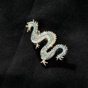 Gothic punk gold dragon brooch with sparkling blue and clear rhinestones on black silk