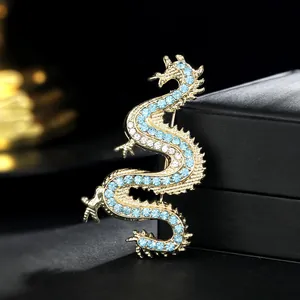 Macro detail of gothic dragon brooch with blue rhinestones on black leather surface