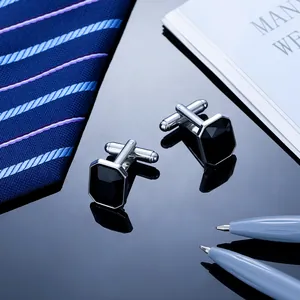 Mens silver cufflinks with octagon black gemstone set against navy blue necktie