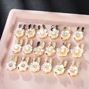 French style floral cufflinks set with pearls and crystals on light pink tray