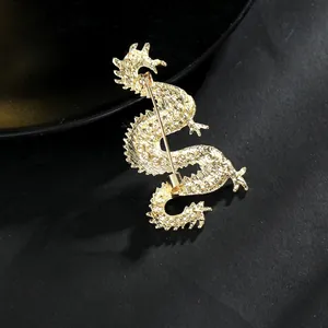 Detailed back view of golden dragon brooch showing metal pin buckle and scale texture