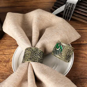 Macro view of vintage gold alloy napkin rings with green enamel and star crescent moon