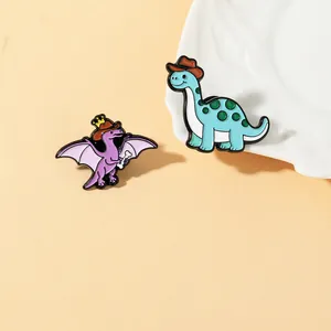 Dettaglio di spille in smalto a forma di dinosauro con pterosauro viola e brachiosauro blu