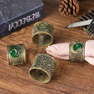 Detail of vintage bronze napkin rings with green enamel star and moon pattern