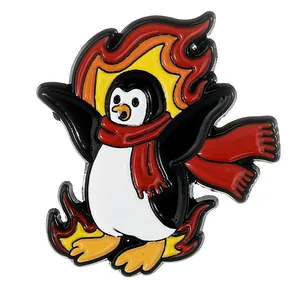 Détails d'un pin's en émail de pingouin avec écharpe rouge et motifs de flammes