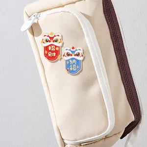 Par de broches de esmalte de león chino tradicional para la suerte en un bolso
