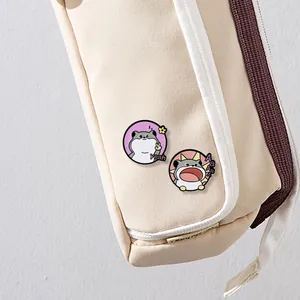 Detail of cute hamster enamel pins on a beige canvas bag showing creative expressions