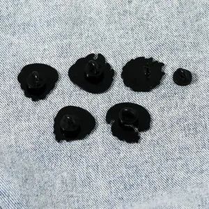 Détail de cinq pin's d'animaux avec attaches en caoutchouc noir sur tissu denim