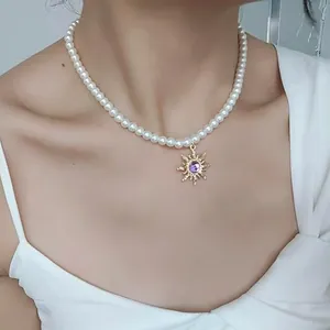 Collier de perles élégant avec pendentif soleil doré et améthyste porté par un mannequin