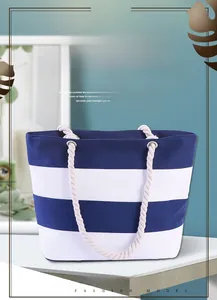Detail of nautical navy striped canvas bag with thick rope handles and metal eyelets