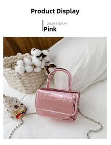 Detailed macro view of pink metallic faux crocodile skin handbag with silver bead chain strap