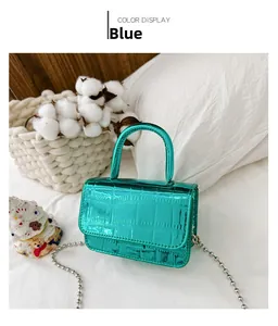 Close-up of metallic blue mini bag with crocodile texture and thin bead chain strap