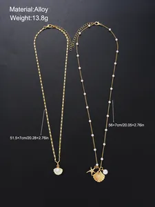 Detail view of gold starfish and shell pendant necklaces with pearl accents on snake chains