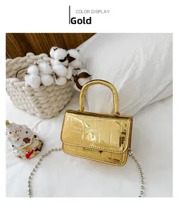 Close-up of shiny gold laser shoulder bag with crocodile pattern and silver bead chain