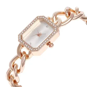 Vue macro d'une montre rectangulaire or rose avec lunette strass et bracelet chaîne