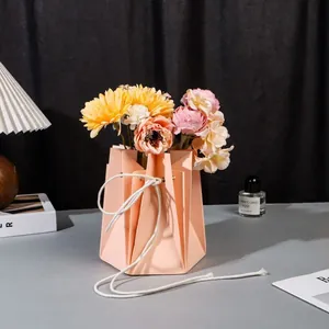 Détail du sac à fleurs hexagonal rose-orange imperméable avec cordon blanc et fleurs