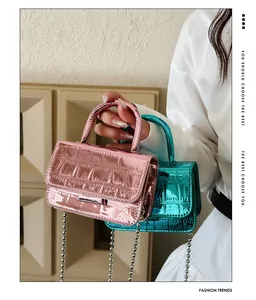 Detail of metallic pink and blue mini bags with crocodile pattern and silver chain