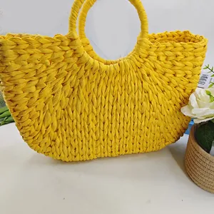 Handmade yellow woven crescent tote bag with round handles for beach vacations