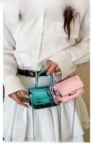 Detailed macro view of metallic green and pink crocodile pattern mini bags with chain