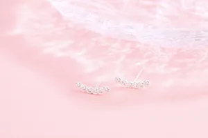 Detailed view of S925 sterling silver curved stud earrings with six sparkling cubic zirconia