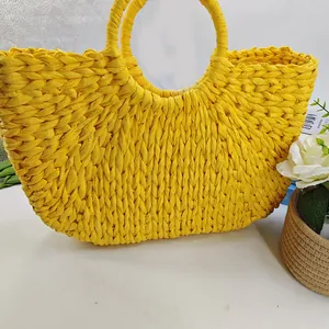 Close-up of bright yellow crochet moon bag with circular handles and V-shaped weave pattern