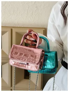 Close-up of girls' mini PU leather handbags with crocodile texture and silver chain straps