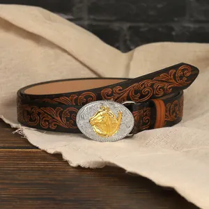 Detail of western cowboy belt featuring floral embossing and golden horse head buckle