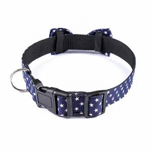 Detail of navy blue cotton dog collar with white stars, plastic buckle, and metal D-ring