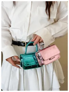 Detail of mini laser crossbody bag showing metallic crocodile texture and chain strap