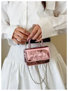 Detail showing the shiny metallic pink crocodile pattern texture and silver ball chain strap