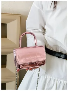 Detailed close-up of girls' laser pink crossbody bag with crocodile pattern and chain strap