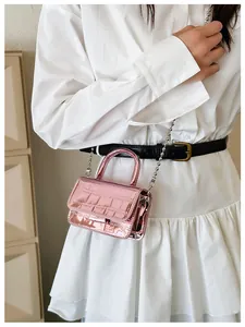 Detail of pink croc-effect mini bag featuring metallic finish and silver ball chain strap