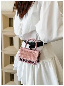 Detail of metallic fuchsia PU leather handbag with crocodile pattern and chain strap