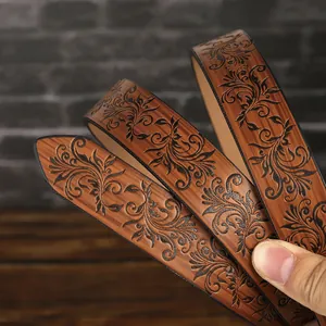 Close-up of vintage embossed leather belt with intricate black vine floral patterns