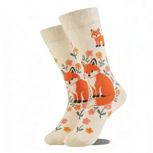 Detail of cream crew socks featuring orange fox and floral knit patterns with ribbed cuffs
