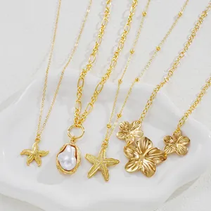 Detail of gold starfish and pearl pendant necklaces arranged on a white ceramic tray