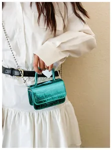 Close-up of metallic green mini bag with crocodile texture and silver ball chain
