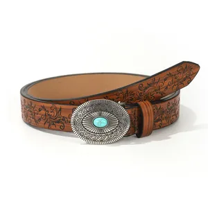 Detail of vintage brown PU belt with western floral pattern and turquoise buckle