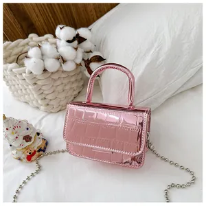 Detail of pink laser leather mini bag with crocodile texture and silver chain strap