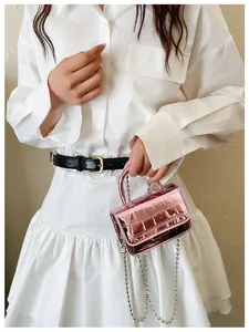 Detail of pink metallic mini crossbody bag with crocodile texture and silver bead chain