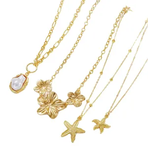 Gold layering necklace set with starfish, pearl, and floral charms on flat snake chain